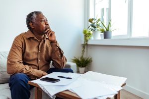 Person reviewing Medicare documents at home with papers, pen, and smartphone on table